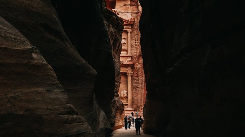 Walking through the Siq canyon in Petra Jordan - narrow gorge with 80 meter sandstone walls